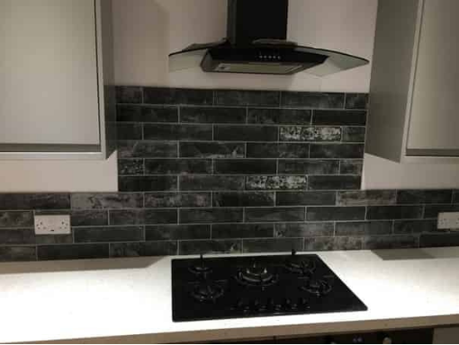 This is a photo of black tiled splash back installed by Cardiff Tiling